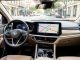 Habitacle moderne vu depuis le siège conducteur, avec un écran central affichant une carte de navigation abstraite et une route urbaine visible à travers le pare-brise.